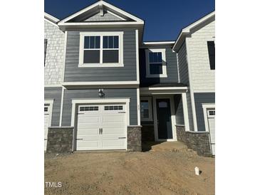Charming townhome featuring a one-car garage, stylish gray siding, and a welcoming front entrance at 13 Silver Pne Dr, Angier, NC 27501