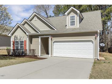 Charming single-Gathering home featuring neutral siding, attached two-car garage, and manicured landscaping at 1709 Heisser Ln, Fuquay Varina, NC 27526