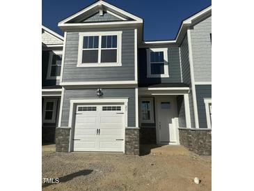 Charming townhome exterior with gray siding, white trim, and a one-car garage at 21 Silver Pine Dr, Angier, NC 27501