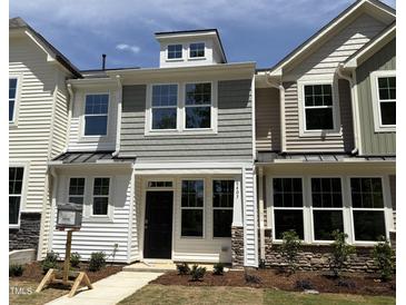 Charming townhome with a black front door, multiple windows, and a combination of lap siding and shake at 6403 Granite Quarry Dr, Raleigh, NC 27610