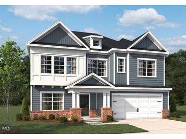 Charming two-story home featuring a mix of white and gray siding, a prominent front-facing garage, and a well-manicured lawn at 720 Compeer Way # 24, Rolesville, NC 27571