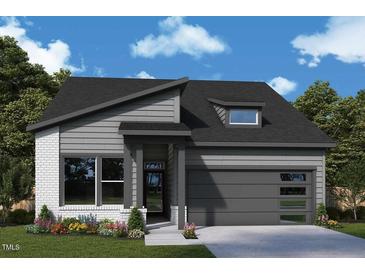 Charming single-story home featuring a modern design, gray siding, brick accents, and a well-manicured front yard at 75 Wabash St, Pittsboro, NC 27312