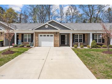 Charming townhome with brick facade, attached garage, and well-manicured front yard and mature trees at 818 Houston Ct, Haw River, NC 27258