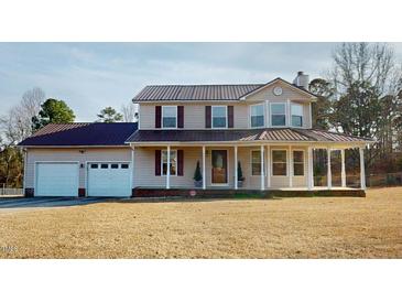 Charming two-story home featuring a spacious front porch and a two-car garage at 96 Overlook Rd, Cameron, NC 28326