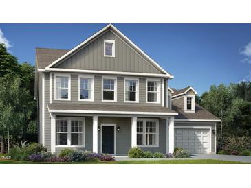 Charming two-story home featuring gray siding, white trim, a welcoming porch, and a neatly landscaped front yard at 1101 Owen Park Drive, Gibsonville, NC 27249