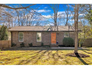 Charming brick home featuring an orange front door and manicured landscaping at 113 Ellen Pl, Chapel Hill, NC 27514