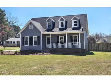 Charming home featuring a covered front porch, dormer windows, and manicured lawn at 117 Woodcroft Drive Dr, Angier, NC 27501