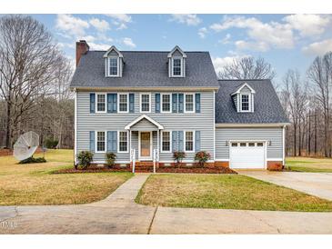 Charming two-story home with blue shutters, gray siding, well-maintained lawn, and attached garage at 205 Fox Hollow Dr, Clayton, NC 27527