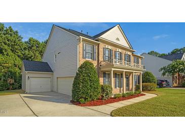 Charming two-story brick home featuring a spacious three-car garage and manicured landscaping at 229 Shillings Chase Dr, Cary, NC 27518