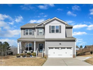 Charming two-story home featuring a covered front porch and a two-car garage at 240 S Stonehaven Way, Clayton, NC 27527