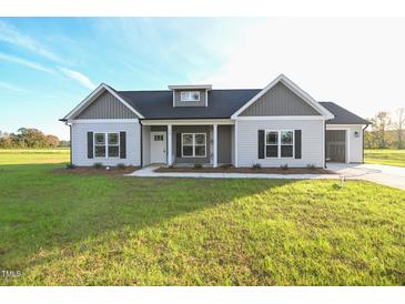 Charming single-story home featuring gray and white siding, black shutters, and a well-manicured lawn at 400 S Eastwood Dr, Benson, NC 27504