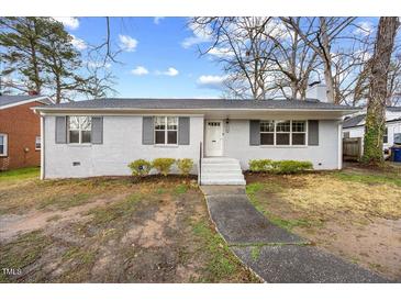 Charming single-story home with a gray brick exterior, gray shutters and a well-manicured lawn at 510 Cross St, Sanford, NC 27330