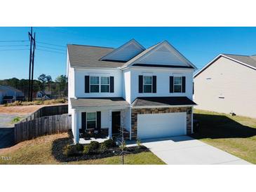 Charming two-story home featuring white siding, dark shutters, and a stone-accented garage at 612 Marian Way, Sanford, NC 27330