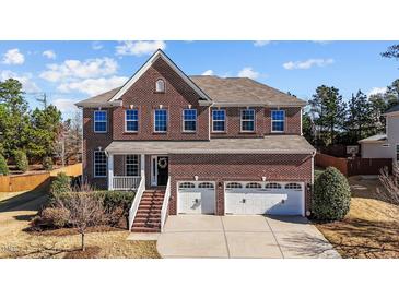 Beautiful two-story brick home with a welcoming front porch and three-car garage at 705 Prince Dr, Holly Springs, NC 27540
