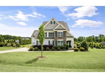 Beautiful two-story home featuring a stone facade and a well-manicured front lawn at 71 Del Corso Ct, Clayton, NC 27527
