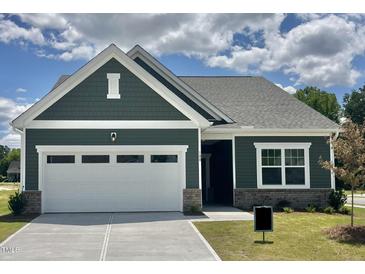 Charming home featuring a well-manicured lawn, a two-car garage, and tasteful exterior color scheme at 100 Big Dream Ct, Louisburg, NC 27549