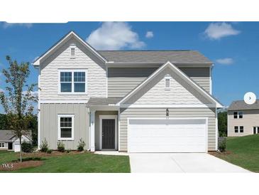 Charming two-story home featuring board and batten and horizontal siding and a two-car garage at 12 Rolling Banks Dr, Louisburg, NC 27549