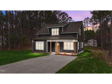 Charming two-story home with dark siding, covered front porch, and well-maintained lawn at 163 Nashua Dr, Louisburg, NC 27549