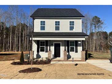Charming two-story home with gray siding, black shutters, and well-manicured landscaping at 260 Longbow Dr, Middlesex, NC 27557