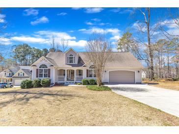 Charming single-Gathering home with a manicured lawn, attached garage, and welcoming front porch at 34 Triton Ct, Clayton, NC 27520