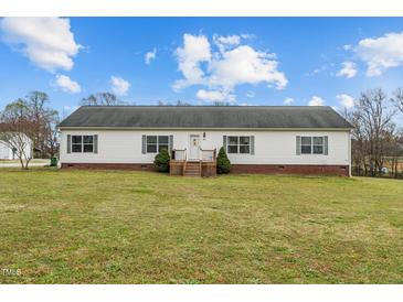 Charming single-story home with white siding and a well-maintained front lawn on a sunny day at 4194 Abattoir Rd, Angier, NC 27501