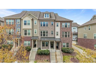 Charming townhomes feature a mix of brick and siding exteriors and inviting front porches at 556 Village Loop Dr, Apex, NC 27502