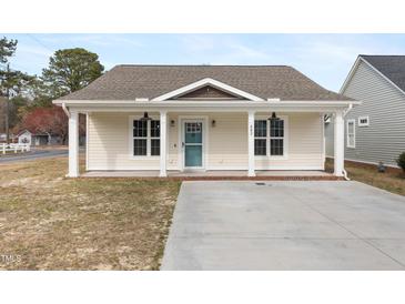 Charming single-story home featuring a covered front porch and a well-maintained yard with new driveway at 600 Cuddington Ln, Nashville, NC 27856