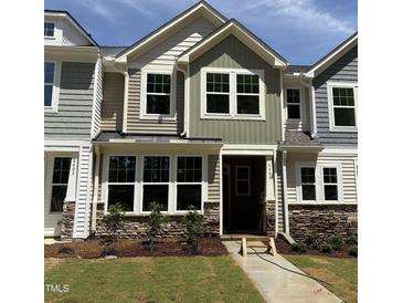 Charming two-story townhome with stone accents, manicured lawn, and welcoming entrance at 6405 Granite Quarry Dr, Raleigh, NC 27610
