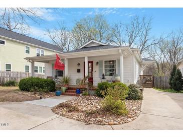 Charming home featuring a landscaped front yard, welcoming front porch and a driveway, offering classic appeal at 711 S East Street St, Raleigh, NC 27601