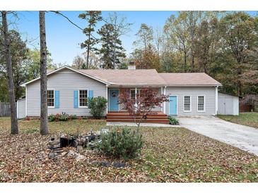 Charming single-story home with light gray siding, blue shutters and door, and a well-maintained front yard at 928 Magnolia Ridge Way, Fuquay Varina, NC 27526