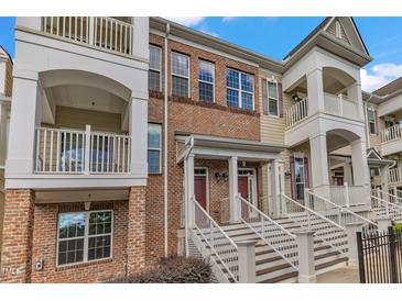 Brick townhouse with multiple stories and balconies featuring white railings and a front entrance with steps at 10210 Sablewood Drive # 112, Raleigh, NC 27617