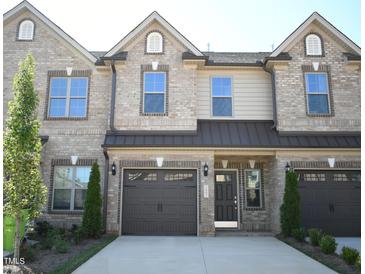 Charming townhome featuring a brick facade, an attached garage, and a well-manicured front yard at 1043 Beechcraft Dr # 120, Mebane, NC 27302