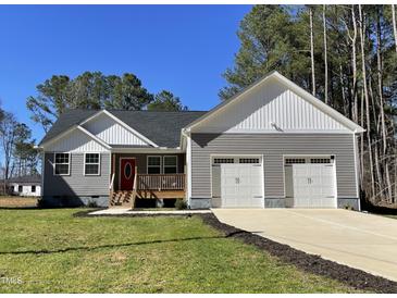 Beautiful exterior view of a craftsman style home with a covered porch, gray siding and a two-car garage at 112 Wichita Way, Louisburg, NC 27549