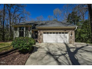 Charming home featuring a brick facade, a two-car garage and a well-manicured lawn at 114 Twin Springs Ln, Angier, NC 27501