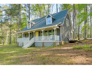 Charming exterior view of home featuring a welcoming front porch and well-maintained lawn at 1301 Flying Hawk Rd, Apex, NC 27523