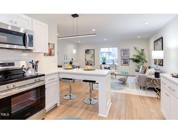 Bright open-concept living room featuring sleek, modern furniture and an eat-in kitchen island at 1309 Hudson Ave # D7, Durham, NC 27705