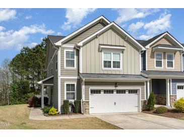 Charming two-story home featuring a gray exterior, attached garage, and well-maintained landscaping at 2418 Pecan Ridge Way, Apex, NC 27502