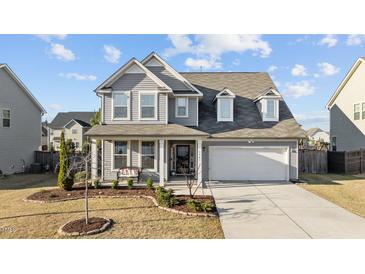 Charming two-story home with a well-manicured front yard and inviting covered porch with a bench at 3541 Fairstone Rd, Wake Forest, NC 27587