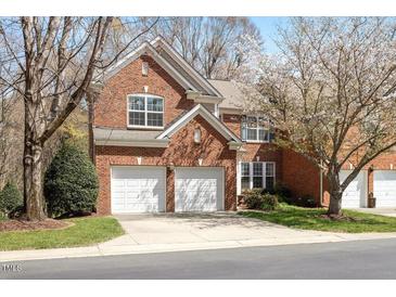 Charming red brick two-story home with a two-car garage and mature landscaping at 5036 Isabella Cannon Dr, Raleigh, NC 27612