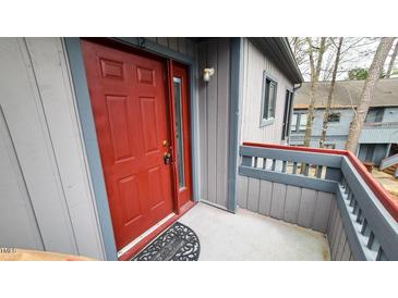A red front door framed by grey trim and siding creates an inviting entrance to the home at 12 Melstone Turn, Durham, NC 27707