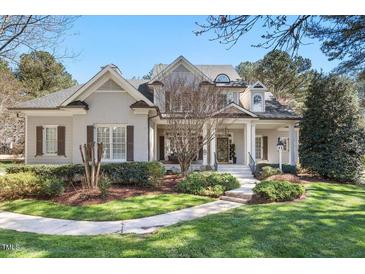 Charming two-story home boasts a manicured lawn and inviting front porch with detailed trim work at 1321 Colonial Club Rd, Wake Forest, NC 27587