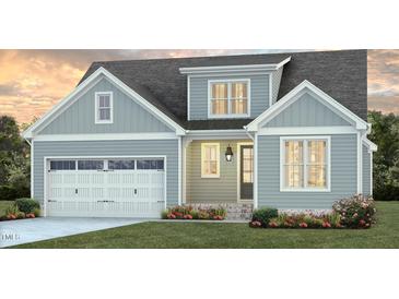 Charming two-story home with a covered entrance, garage, and beautifully landscaped front yard at 165 Big Bradley Dr, Wendell, NC 27591