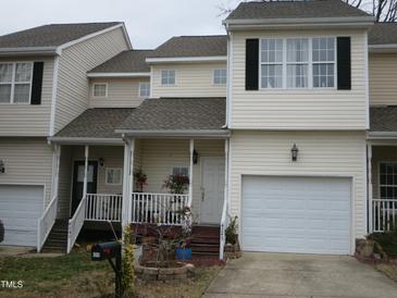 Two-story townhome boasts a one-car garage and a cozy front porch with white railings and steps at 4245 Toccopola St, Raleigh, NC 27604