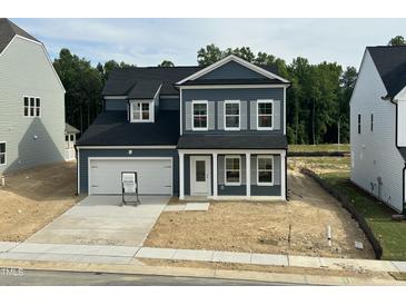 Charming two-story home featuring a covered entry, attached garage, and a classic blue and white color scheme at 704 Compeer Way # 28, Rolesville, NC 27571