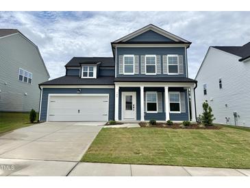 Two-story home with blue siding, white trim, a two-car garage and a well manicured front lawn at 704 Compeer Way # 28, Rolesville, NC 27571
