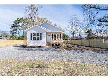 Charming single story home with light siding, dark shutters, a gravel driveway, and small front porch at 818 E Holly St, Rocky Mount, NC 27801
