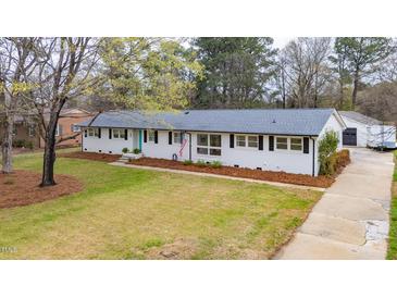 Charming single-story home featuring a well-manicured lawn, classic black shutters, and an inviting turquoise front door at 928 Hanford Rd, Graham, NC 27253