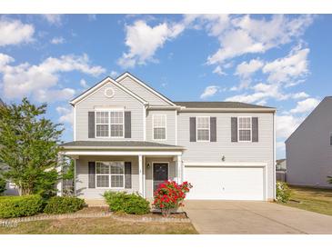 Charming two-story home with a well-manicured lawn and attached two-car garage at 1009 Limeberry Ct, Clayton, NC 27520