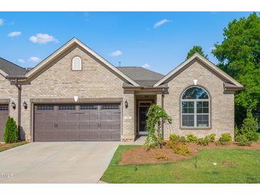 Inviting brick home featuring an attached garage and a manicured lawn at 1053 Beechcraft Dr # 124, Mebane, NC 27302