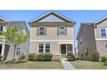 Charming two-story home with a well-manicured lawn, inviting entryway, and beautiful landscaping at 109 Belle Plain Dr, Morrisville, NC 27560